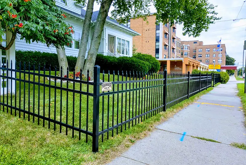 A black ornamental metal fence surrounding a property.